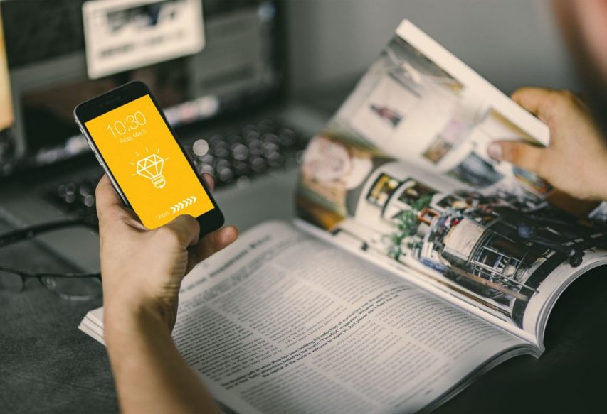 Man holding iPhone With magazine Mockup PSD | Download Mockup